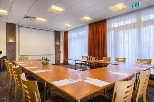 a conference room with tables and chairs and a whiteboard at Garner Hotel Bochum by IHG in Bochum