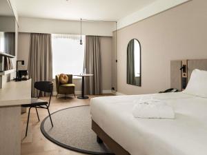 a hotel room with a bed and a desk at Mercure Liege City Centre in Liège