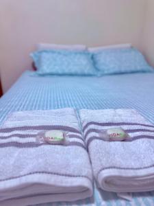 a blue bed with towels and pillows on it at FLAT -Apartamento na Pedreira Belém in Belém