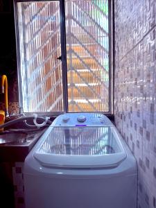 a bath tub in a bathroom next to a window at FLAT -Apartamento na Pedreira Belém in Belém