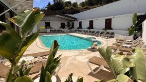 a pool with chaise lounge chairs and a resort at Harpazul in Catoira