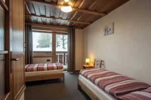 a bedroom with two beds and a window at Podhradkom in Závažná Poruba