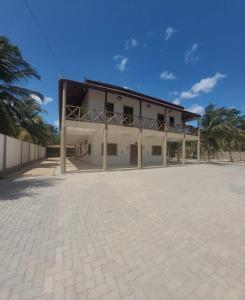 a large white building with a large courtyard at Casa da Bênção - Praia de Moitas in Amontada +4 photos