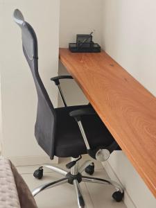 a wooden desk with a black office chair at Apartamento Charme e Aconchego da Serra in Petrópolis