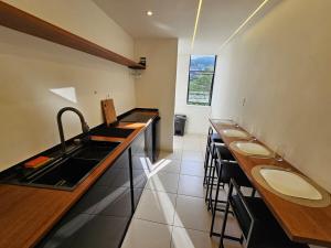 a kitchen with a row of sinks and a counter at Apartamento Charme e Aconchego da Serra in Petrópolis