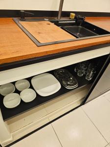 a kitchen drawer with white plates and a sink at Apartamento Charme e Aconchego da Serra in Petrópolis +29 photos