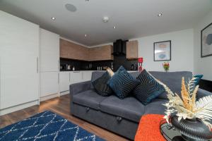 a living room with a gray couch and a kitchen at LUSH 2 Bed Central Apartment Hull Centre in Hull