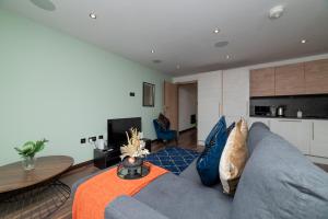 a living room with a blue couch and a table at LUSH 2 Bed Central Apartment Hull Centre in Hull