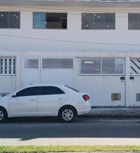 a white car parked in front of a building at Sobrado Beira Mar 25m da Praia in Peruíbe