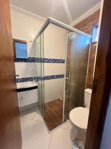 a bathroom with a shower and a toilet at Sobrado Beira Mar 25m da Praia in Peruíbe