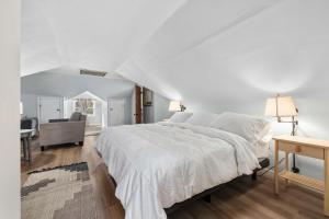 a white bedroom with a large bed and a desk at Family Friendly Home - Fenced yard - Parking in Fort Wayne