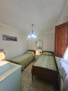 a bedroom with two beds and a dresser and a mirror at La Corte del Tadde in Lammari