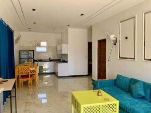 a living room with a blue couch and a kitchen at The View Nile Villa in Jazīrat al ‘Awwāmīyah