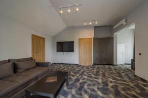 a living room with a couch and a flat screen tv at Forty One Luxury Spa in Belgrade