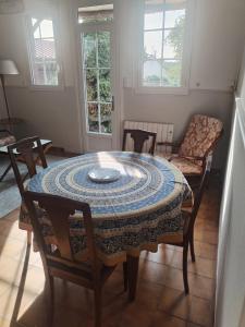 a room with a table and chairs and windows at Chez mamie Jeannine in Gouville