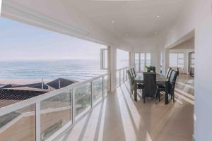 a dining room with a table and a view of the ocean at Beach Penthouse in Mtwalume in Umtwalumi