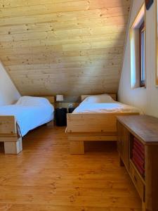 a bedroom with two beds in a log cabin at Rojnik Mountain Farm 