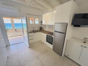 a kitchen with a refrigerator and a view of the ocean at Lighthouse in Kallirákhi
