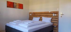 ミュンジンゲンにあるÜbernachten im Münsinger "Albgut" - Hotelzimmer, Ferienwohnungen und Stubenの白いシーツのベッドがある寝室