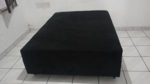 a black bench sitting on a tile floor at Suíte por temporada in Belém