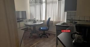 a small kitchen with a table and a chair in it at Sundon Park - 1 Bed Flat in Luton