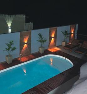 ein Swimmingpool auf einer Terrasse mit Pflanzen und Lichtern in der Unterkunft Morada do Rio in Prado