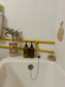 una vasca da bagno con due bottiglie sopra di A cozy cottage in Tomar a Tomar