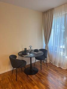 a table and chairs in a room with a window at 30 min from Munich & S-Bahn apartment with garden in Gauting +19 photos