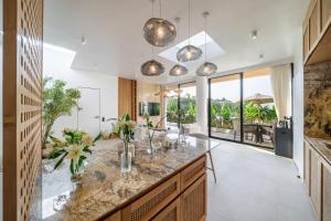 an open kitchen with a large island with marble countertops at Ardhana 10 - Family-Friendly Villa - Private Pool - Prime Bali Location in Ungasan