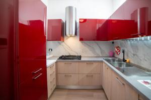 a kitchen with red cabinets and a red refrigerator at La Coccola by Andrea in Castelfranco Emilia