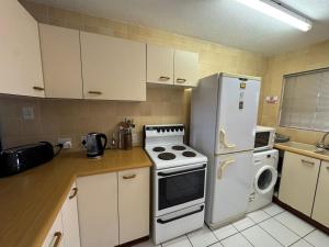 a kitchen with a white refrigerator and a stove at Cicada 8 in Ramsgate