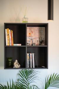 a black book shelf with books on it at La Coccola by Andrea in Castelfranco Emilia +28 photos
