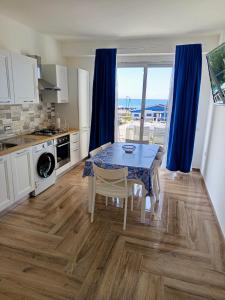 a kitchen with a table and a dining room with a view at Solleone - Appartamento 9C in Paestum