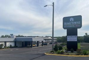 a sign in front of a building with a home tongue studios sign at HomeTowne Studios by Red Roof Athens, TN in Athens