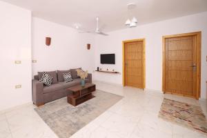 a living room with a couch and a flat screen tv at Serenity House Luxor in Luxor