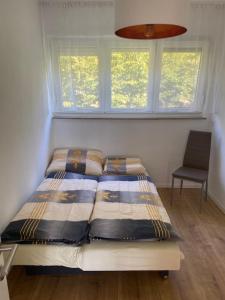 a bed in a bedroom with a window and a chair at City Apartment Göppingen - Neu Renoviert & Voll Ausgestattet, Moderne Wohnung mit Küche & Balkon in Göppingen