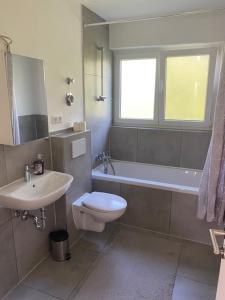 a bathroom with a sink and a toilet and a tub at City Apartment Göppingen - Neu Renoviert & Voll Ausgestattet, Moderne Wohnung mit Küche & Balkon in Göppingen
