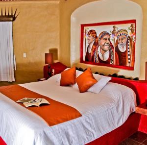 a bedroom with a large bed with a painting on the wall at Matices Hotel de Barricas in Tequila +61 photos
