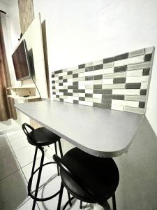 uma mesa e dois bancos em uma sala em Alto Mar Studio em São Vicente