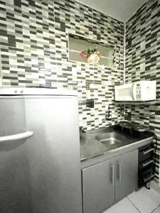 a kitchen with a refrigerator and a sink at Alto Mar Studio in São Vicente