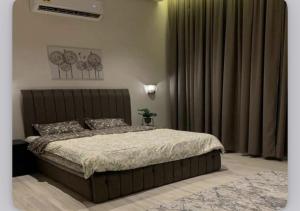 a bedroom with a large bed and curtains at Naseem Sur  +10 photos