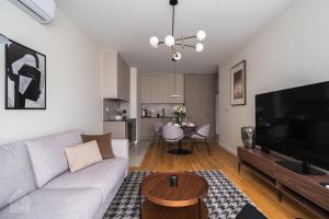 a living room with a couch and a tv and a table at Grzybowska Luxury Apartment with Skyline View by House Expert Warsaw in Warsaw