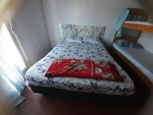 a small bedroom with a bed with a red blanket at Quintana in Asunción