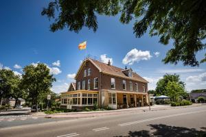 a building with a flag on top of it on a street at Den Eikenboom in Loenen