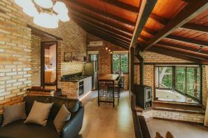 a living room with a couch and a kitchen with a tub at Odoyá Cabana à beria-mar in Governador Celso Ramos