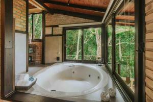 a large bath tub in a room with windows at Odoyá Cabana à beria-mar in Governador Celso Ramos +39 photos