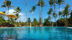 a swimming pool with palm trees in the background at Porto do Sol - Chalé 25 in Pipa +56 photos