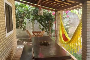 a patio with a hammock and a table and chairs at Porto do Sol - Chalé 25 in Pipa