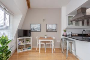 a kitchen with a table and chairs in a room at Stylish 1 Bedroom Apartment Near Northcote Road in London