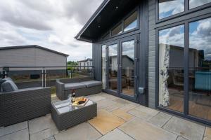 a patio with wicker chairs and a table at Briargate 38 in Burnham Market